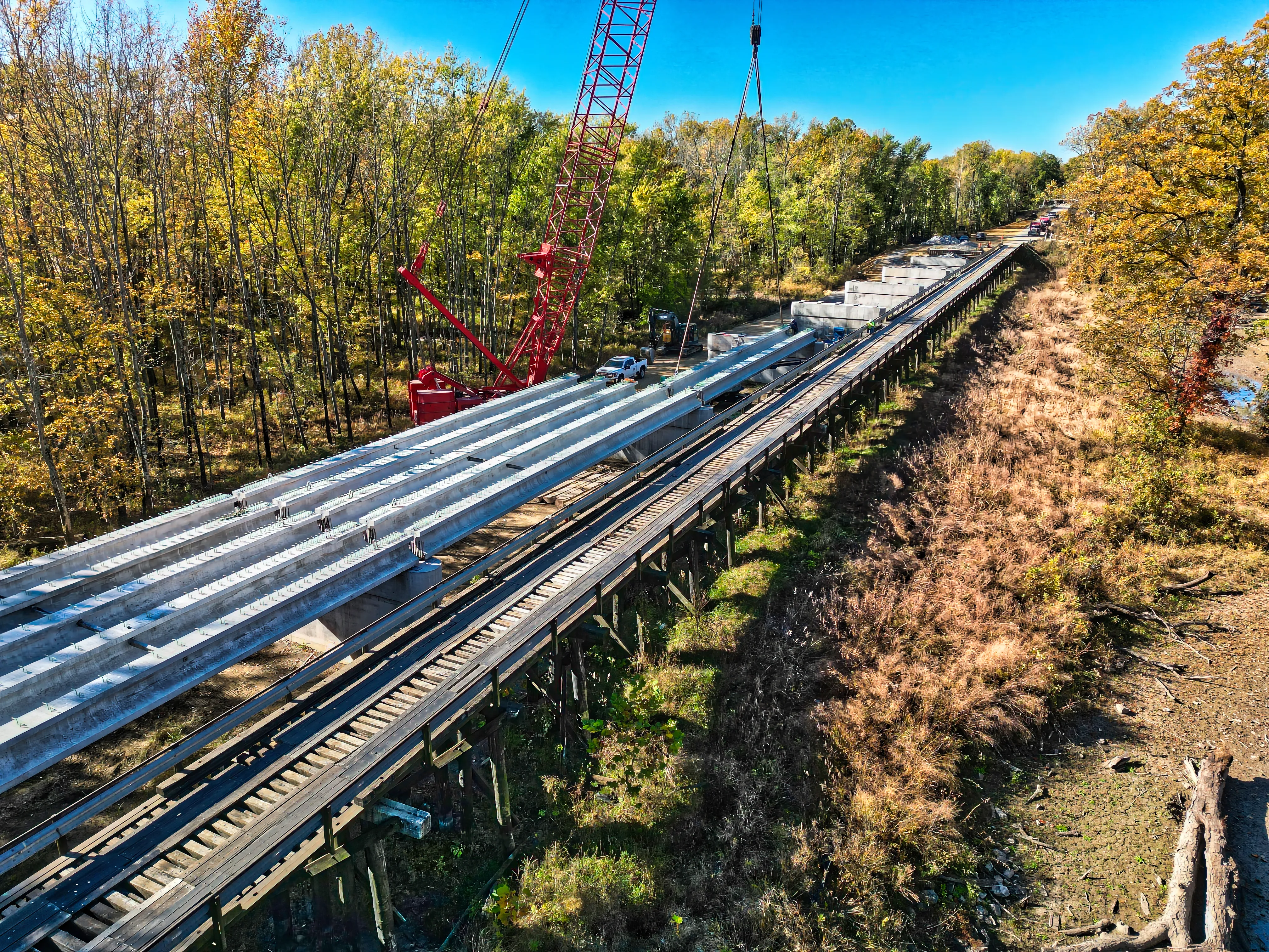 Precast concrete bridge beams being set alongside the historic Wabash Cannonball Bridge