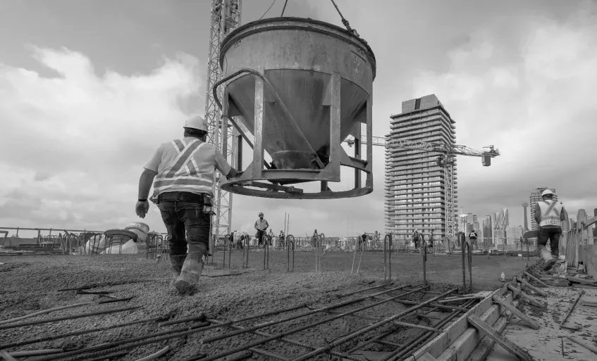 Concrete placement on a high-rise deck, bucket swinging over mat reinforcement